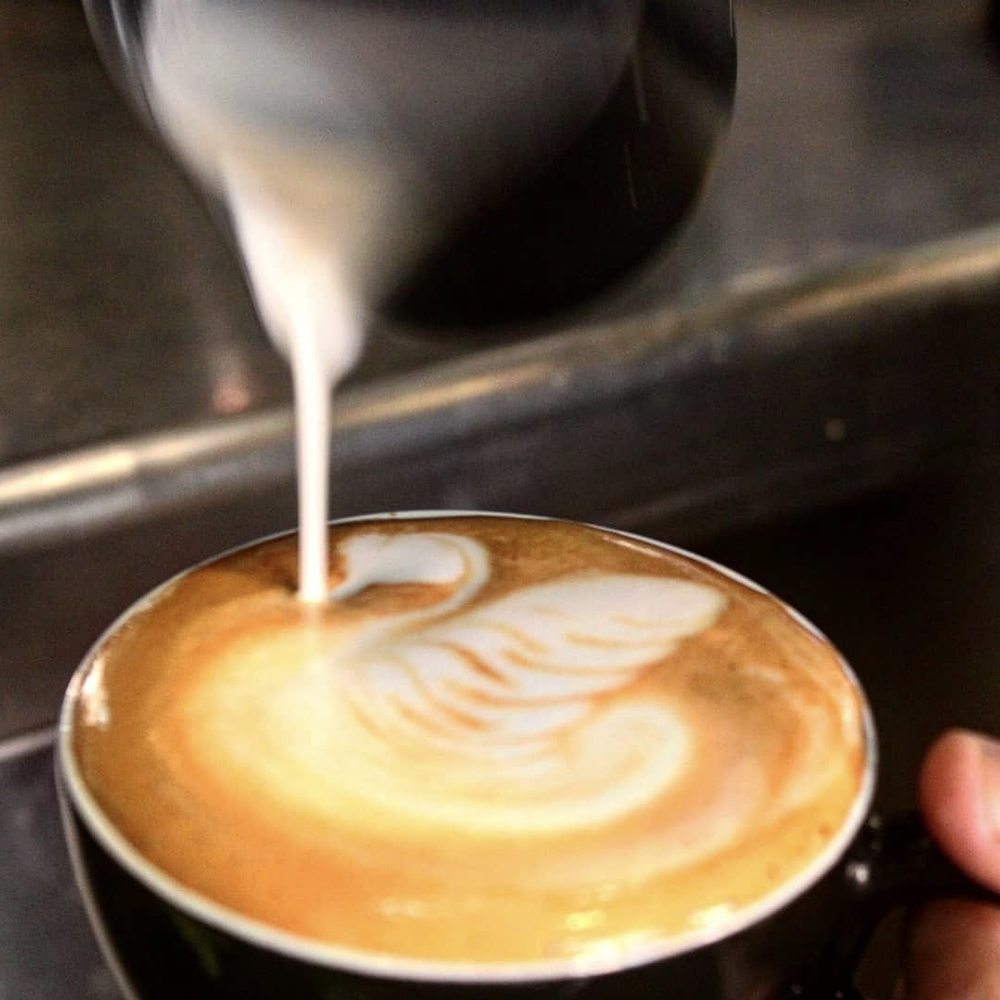 Leche vegetal vertida sobre un espresso formando el latte art