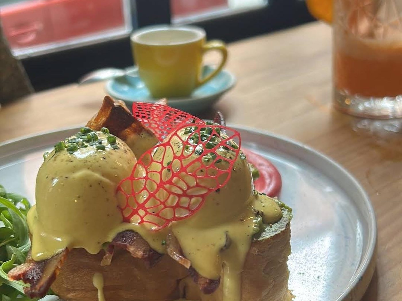 Mesa de Frutas Prohibidas a media tarde: huevos Benedict, un café y un zumo