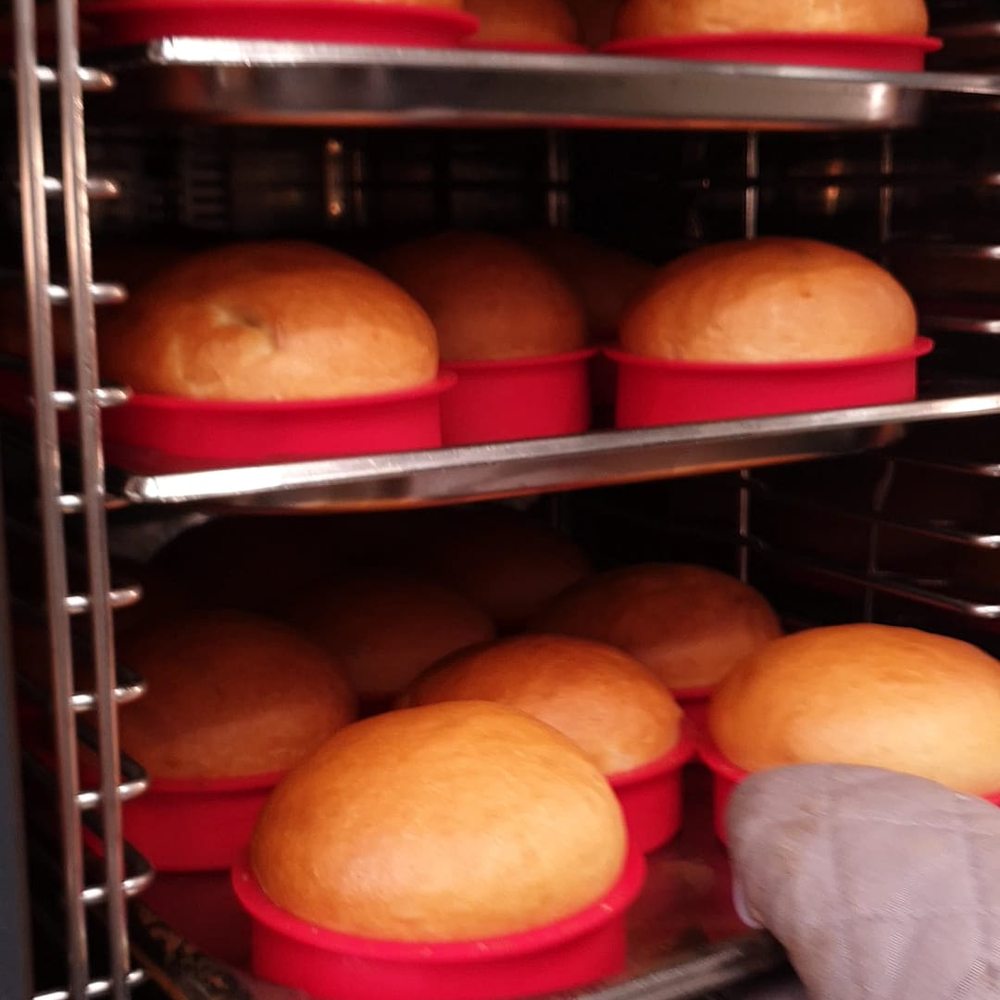 Bandejas de brioche recién horneado saliendo del horno del obrador