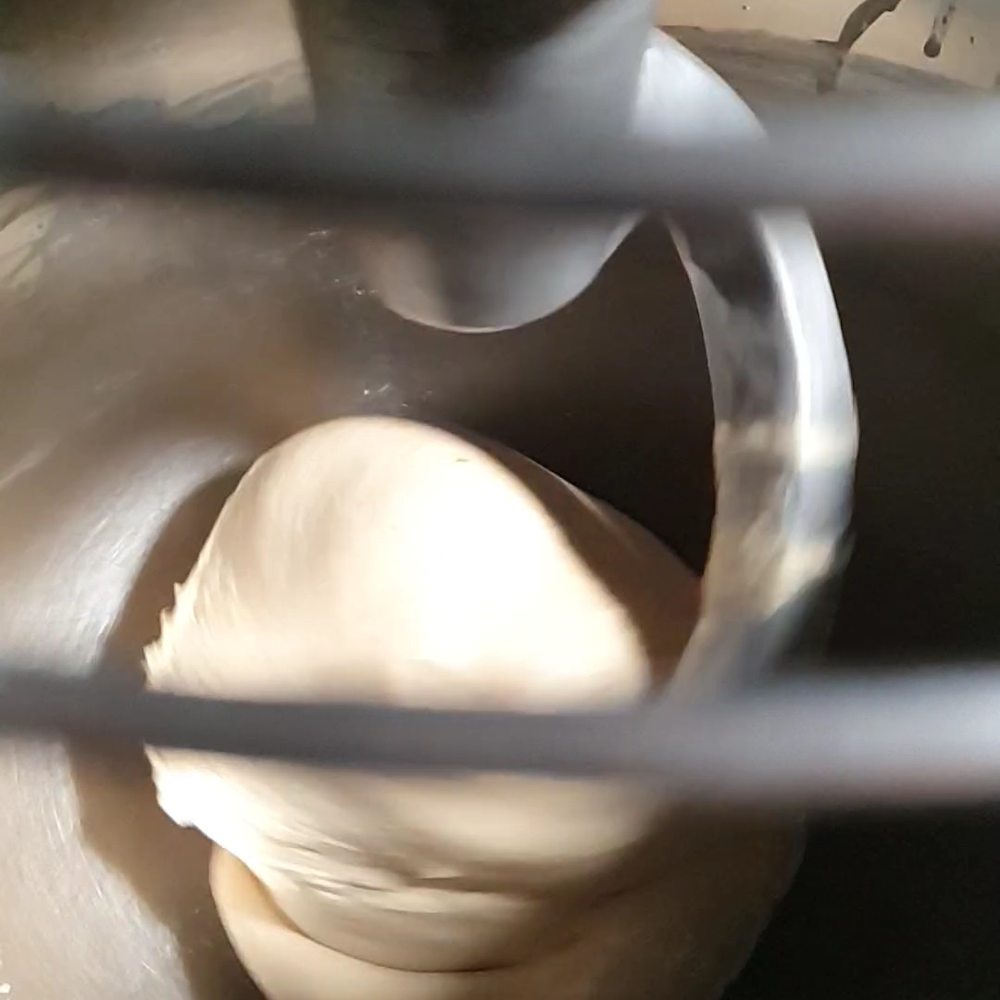 Masa de brioche girando en el gancho de la amasadora