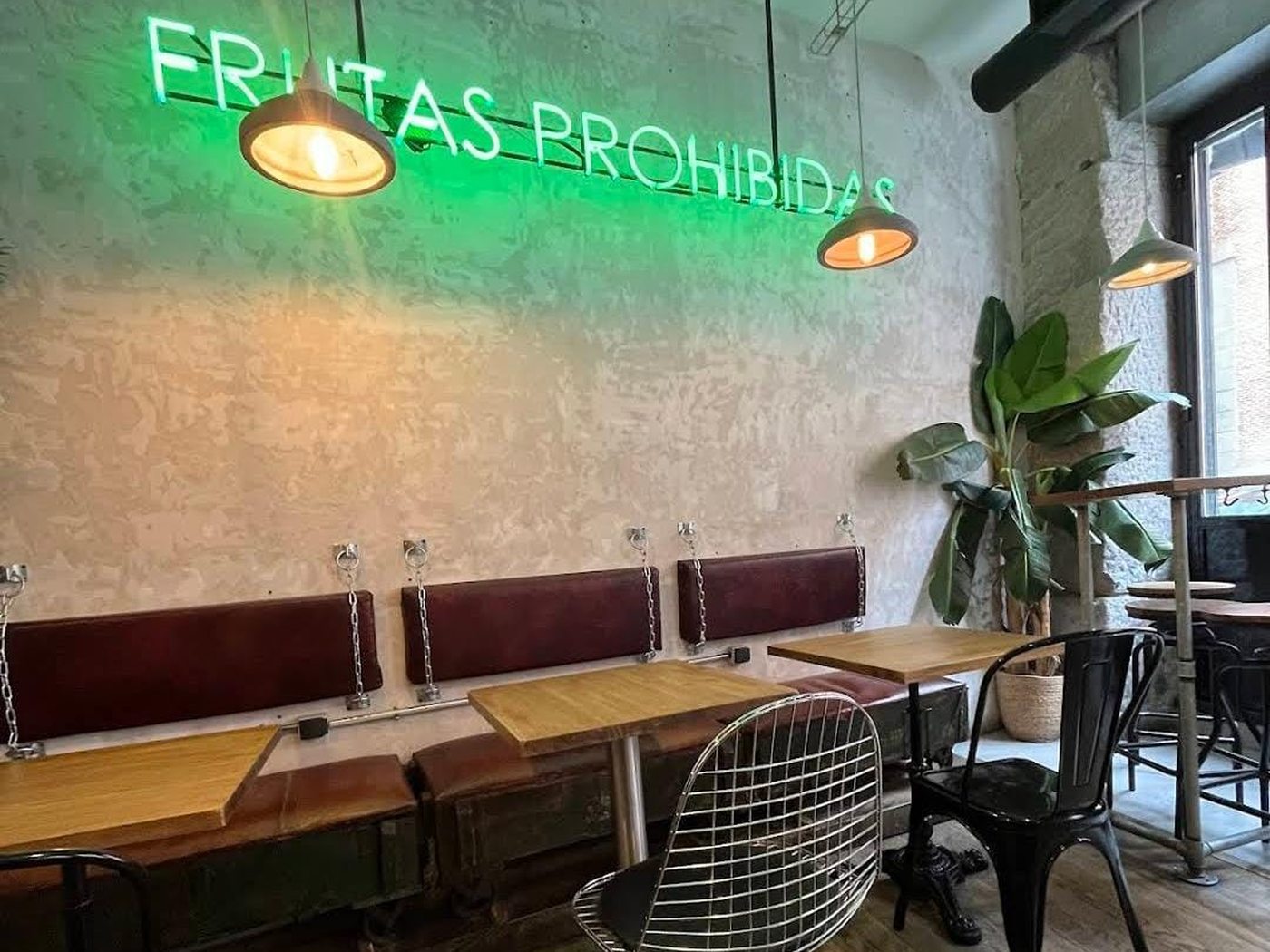 Sala de Frutas Prohibidas con el neón verde del nombre sobre los bancos de cuero