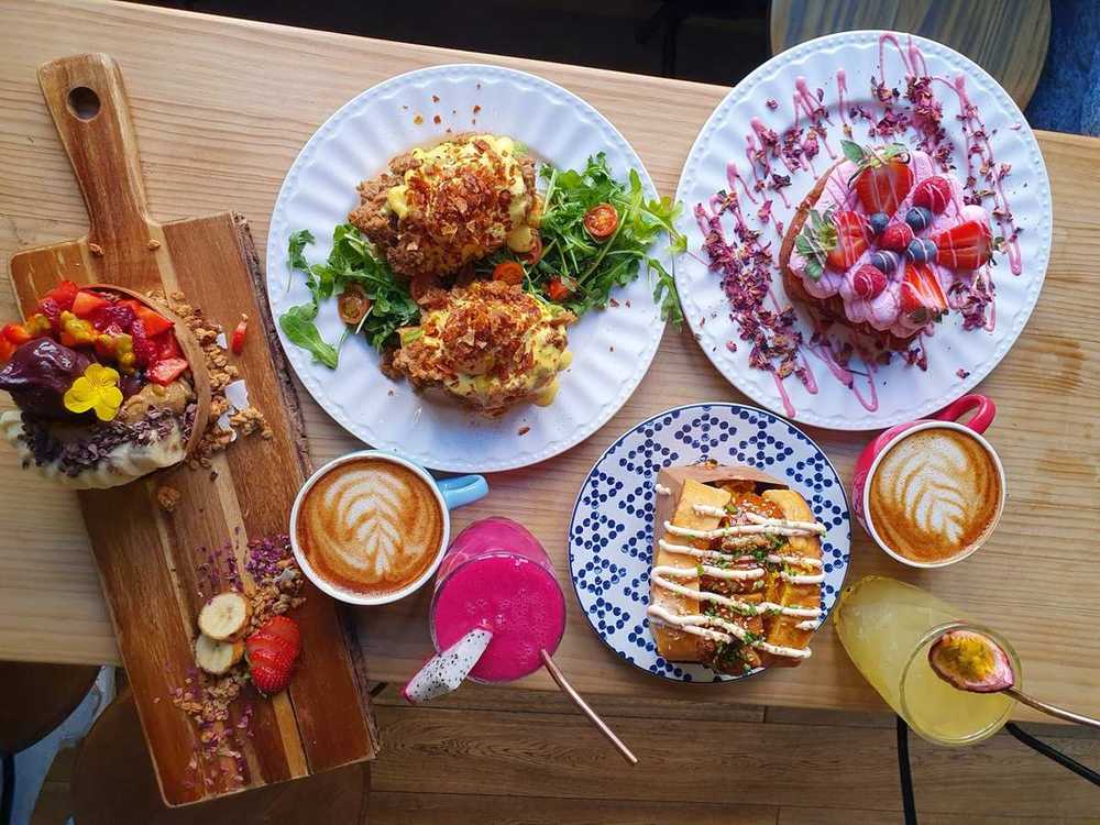 Mesa de Frutas Prohibidas vista desde arriba con varios platos, cafés y zumos